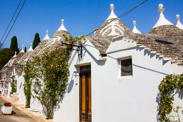 Must-See im Apulien Roadtrip: die Trulli in Alberobello: kleine, weiß getünchte Steinhäuser mit grauem Steinschindeldach