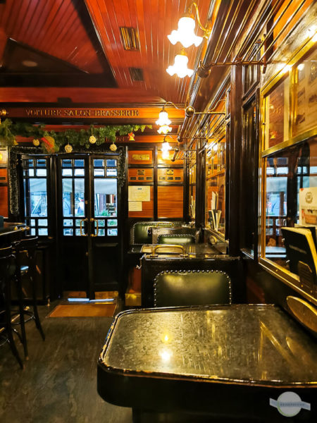 Das Café Orient Express ist eingerichtet wie der alte Zug mit dunklen Möbeln und Holzverschlag