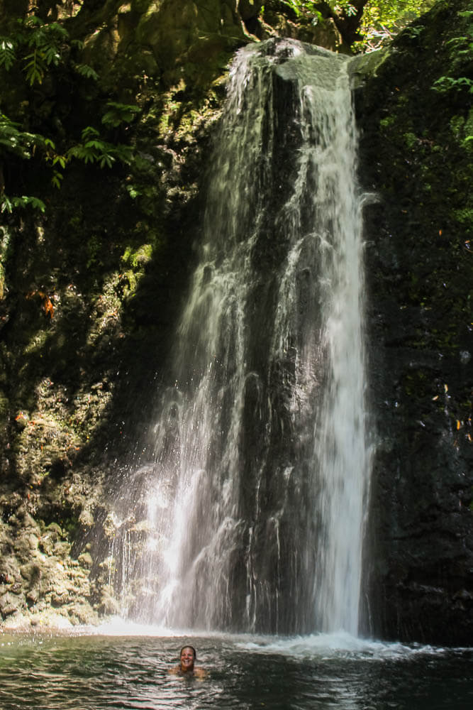Frau in Wasserfall auf den Azoren