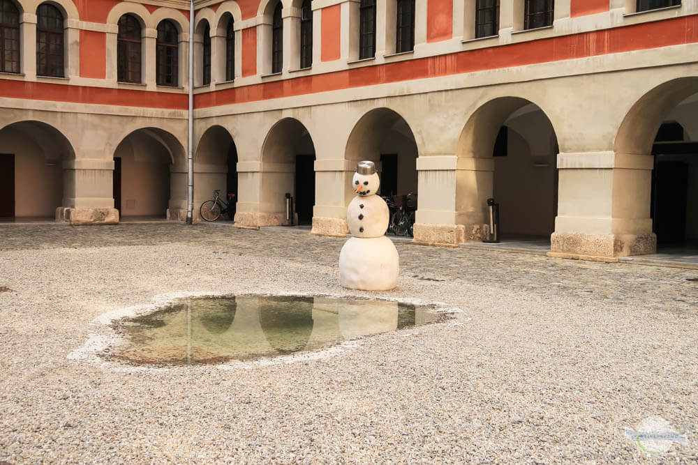 Schneemann vor Pfütze