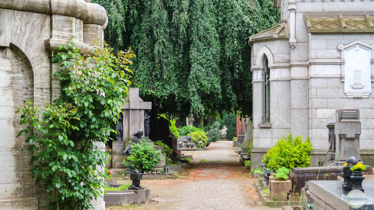 Monumentefriedhof in Mailand: Gehweg zwischen pompösen Grüften und Bäumen