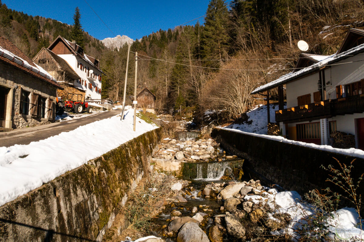 Kleiner Bach mit mehreren Wasserfällen, daneben eine Straße
