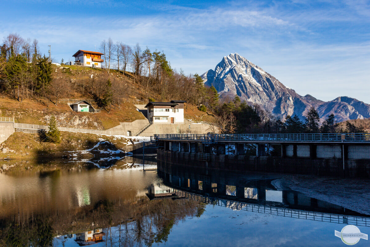 Staudamm in der Carnia mit Berggipfeln im Hintergrund