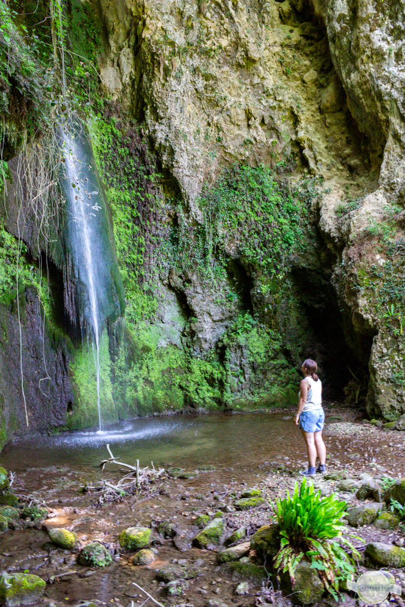 Vor einem Wasserfall stehen