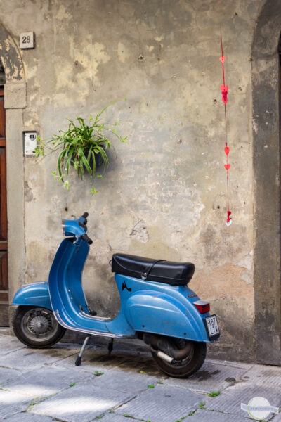 Blaue alte Vespa vor Hausmauer in Italien