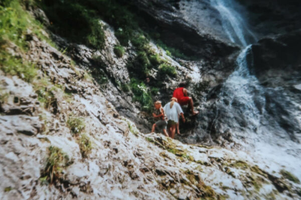 Familie klettert bei Wasserfall herum
