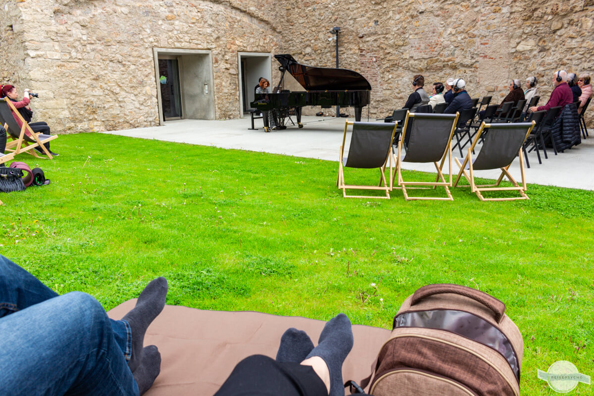 Klassisches Konzert im Freien mit Picknickrucksack und ausgezogenen Schuhen