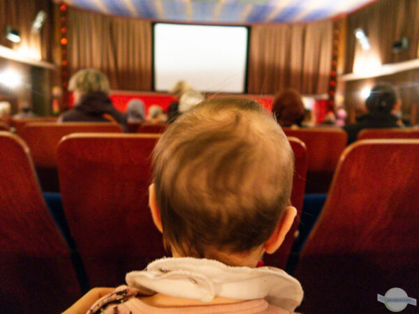 Baby im Kino - Babykopf von hinten mit Blick auf die Leinwand