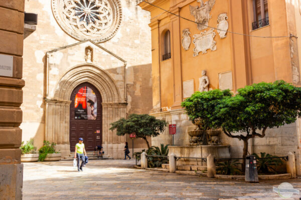 Trapani Straßenszene: Kirche, altes Gebäude und ein Mensch mit Einkäufen