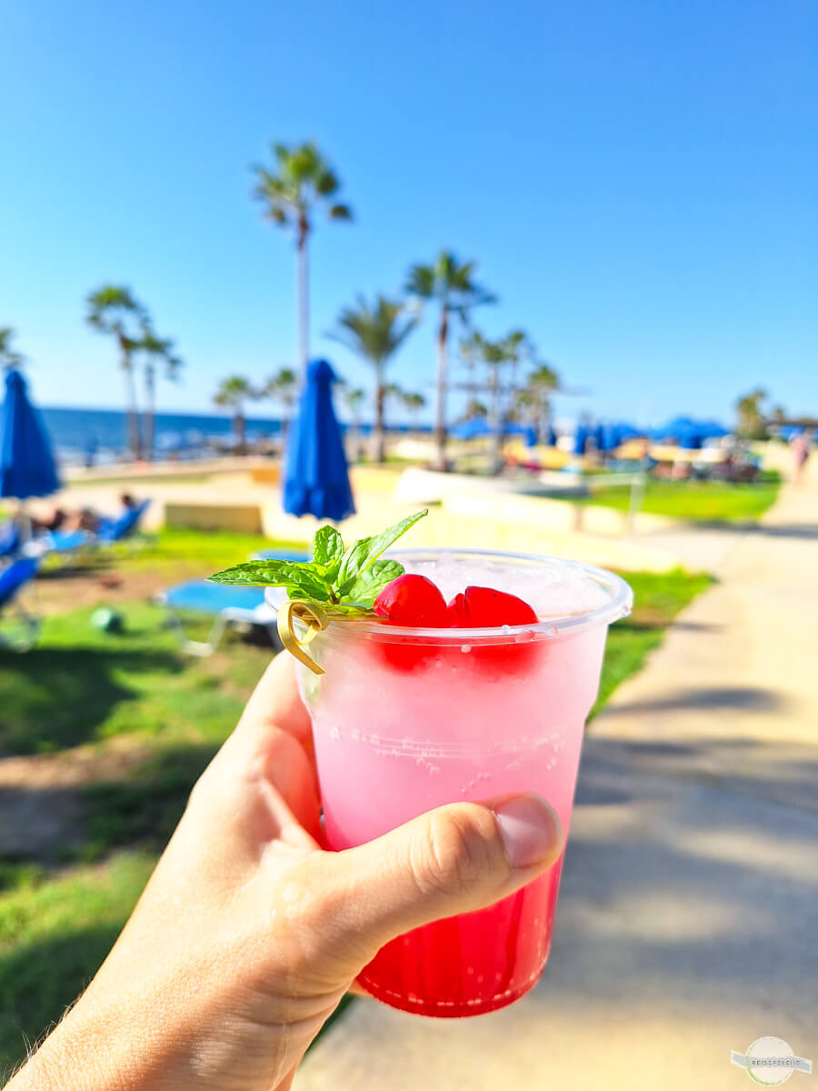 Mit Cocktail am Strand