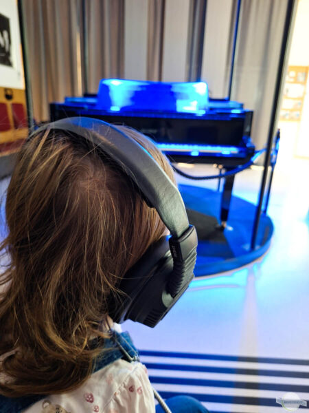 Hörspiel im Salon Stolz - mit Kopfhörern vor dem beleuchteten Klavier